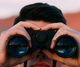 Bildschirmfoto einer h-da Seite mit einem Mann, der durch ein Fernglas schaut